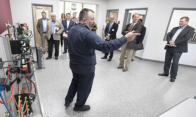 Photo by J.T. Wampler Tyson Sontag, medium- and heavy-duty truck instructor, gives a tour to members of the Legislative Task Force on Workforce Education Excellence on Nov. 1 at the Gentry School District's Career and Technical Education Center. The group met to discuss and tour the center which opened this year and teaches high school students from four districts about nursing, information technology, and diesel technology.