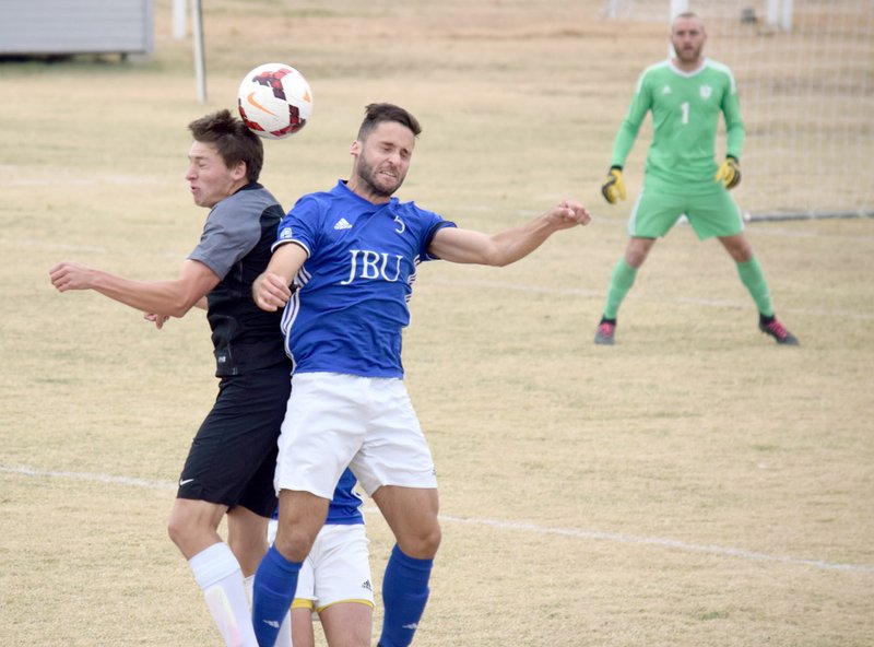 Photo submitted John Brown defender Santiago Vanegas battles a Southwestern Christian defender Monday during the Sooner Athletic Conference men's soccer tournament semifinals as Golden Eagles goalkeeper Adam Holt looks on. Southwestern Christian ended the Golden Eagles' season with a 2-0 victory.