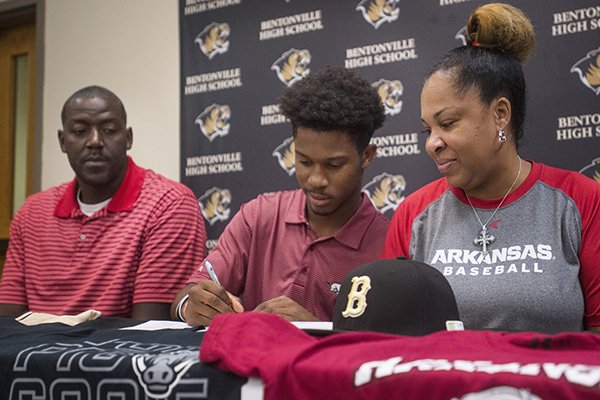 Kam'ron Mays-Hunt, with parents Fess Thompson and Kamra Thompson, signs his national letter of intent to play baseball at Arkansas Wednesday, Nov. 8, 2017, at Bentonville High School's Tiger Athletic Complex.
