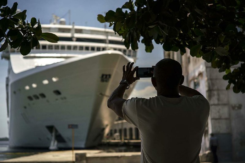 A man photographs a cruise ship in the Havana harbor this June. U.S. rules on travel to Cuba were tightened Wednesday, limiting Americans’ access to the island nation. 