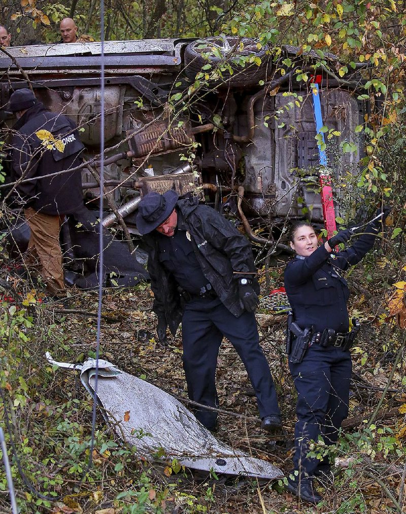 Little Rock police officers investigate a fatal crash Wednesday at 7100 Arch St. in which a speeding car left the roadway and crashed into the woods.