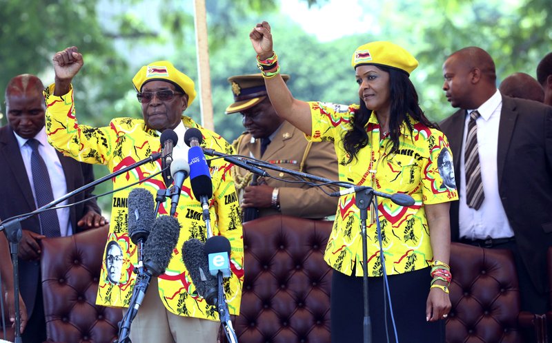 Zimbabwe's President Robert Mugabe, left, and his wife Grace chant the party's slogan during a solidarity rally in Harare, Wednesday, Nov. 8, 2017. Zimbabwe's president said Wednesday he fired his deputy and longtime ally for scheming to take power, including by consulting witch doctors. Now Mugabe's wife appears poised for the role. (AP Photo)