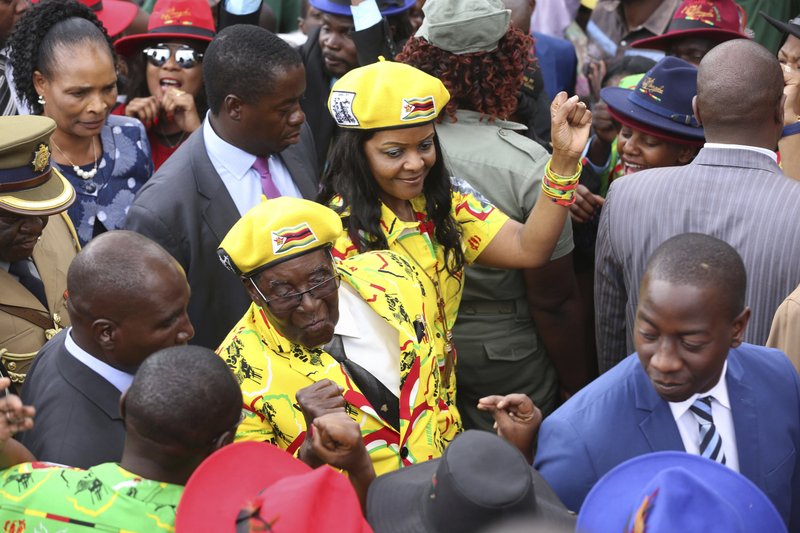 Zimbabwe President Robert Mugabe, center left, and his wife Grace greet supporters upon arrival for a solidarity rally in Harare, Wednesday, Nov. 8, 2017. Zimbabwe's president said Wednesday he fired his deputy and longtime ally for scheming to take power, including by consulting witch doctors. Now Mugabe's wife appears poised for the role. (AP Photo)