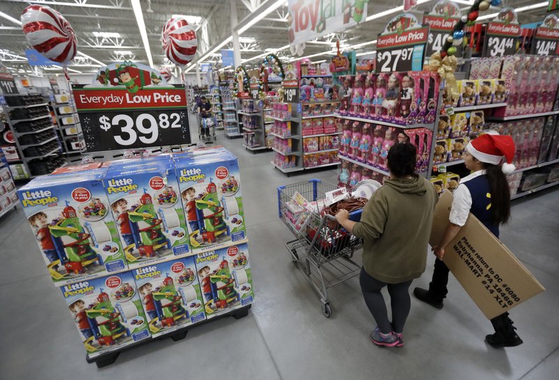 A shopper, left, walks with a store associate in the toy section at Walmart in October 2016 in Teterboro, N.J. Walmart hopes to tempt shoppers with online deals before Black Friday. It’s beginning some online deals Thursday and plans to offer most of its Black Friday deals online starting at 12:01 a.m. on Thanksgiving. (AP Photo/Julio Cortez, File)
