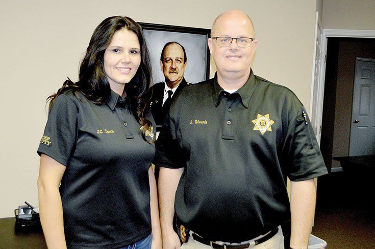 Faulkner County Chief Deputy Coroner Jessica Thorn and interim Coroner Robert Edwards stand in front of a photo of longtime coroner Patrick F. Moore, who died Sept. 4. Edwards and Thorn are finalists for the position, and Faulkner County Judge Jim Baker said he will make a recommendation for coroner Nov. 21 to the Faulkner County Quorum Court.