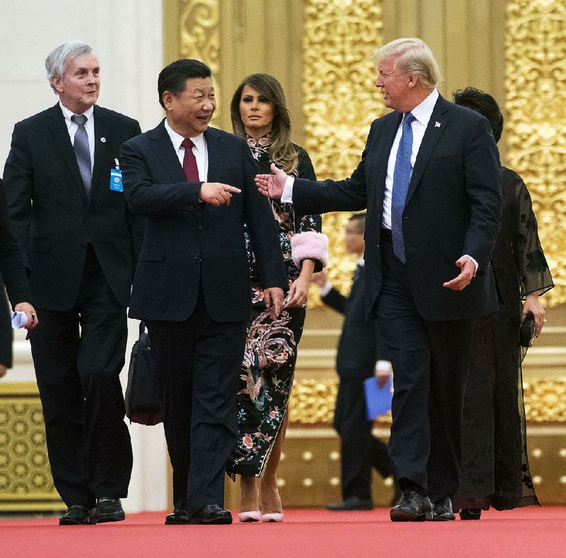 Chinese President Xi Jinping and President Donald Trump lead the way Thursday as they and their wives arrive for a state dinner in Beijing. 
