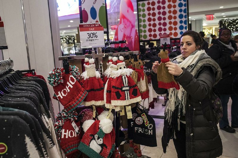 A shopper looks at hats displayed at a Macy’s store in New York just before Christmas last year. The retailer on Thursday reported a third-quarter profit of $36 million. 