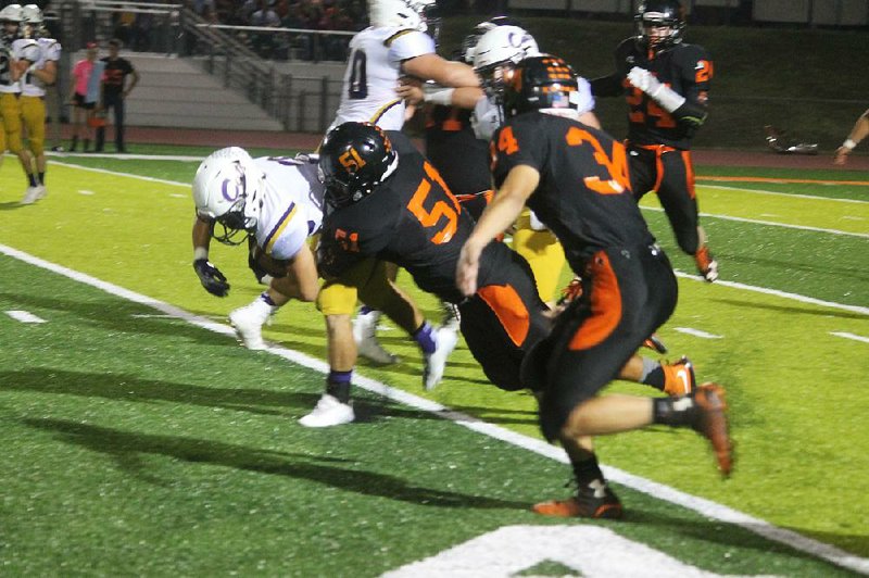 Waldron’s Gerardo Lopez (51) tackles Andrew Robertson of Booneville on Oct. 13. The Bulldogs take on Pea Ridge tonight in their first playoff appearance since 2003.