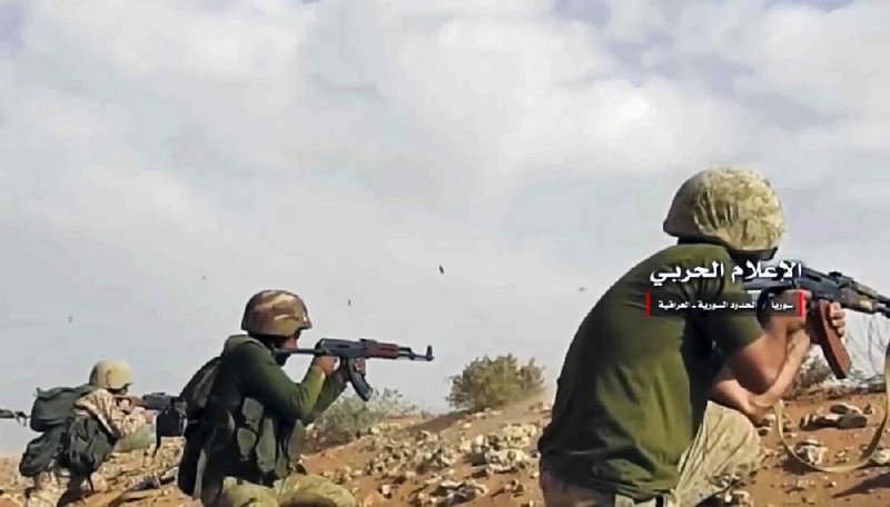 Syrian pro-government troops fire on Islamic State militant positions on the Syria-Iraq border in this image taken from a Syrian military website. 