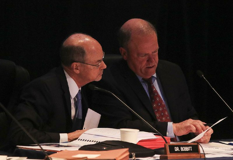 University of Arkansas System President Donald Bobbitt (left) talks with University of Arkansas board of trustees Vice Chairman Mark Waldrip on Thursday during a meeting in North Little Rock. 
