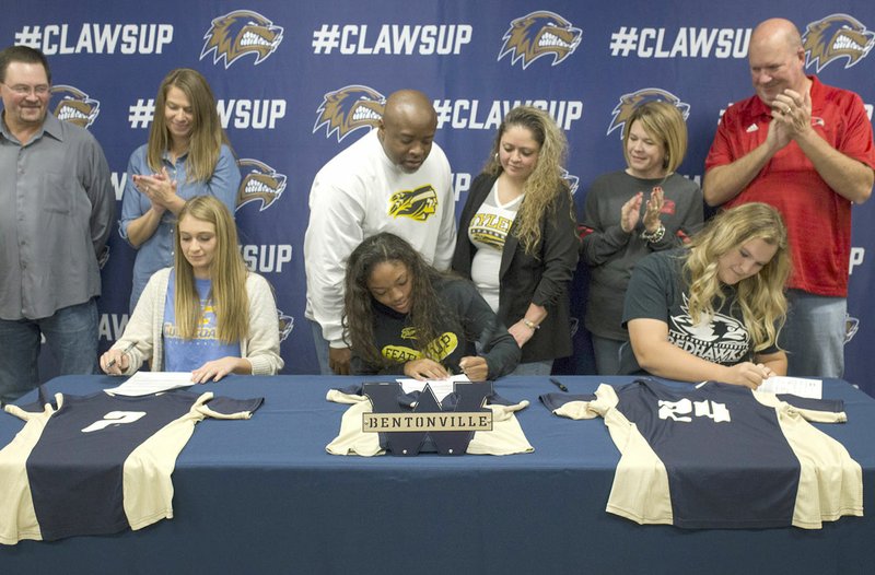 Brittany Crowson (from left), Jazmine Dodd and Anna Griffin sign letters of intent Thursday at Bentonville West High School in Centerton. Crowson signed with Gulf Coast Community College, Dodd with Tyler Junior College and Griffin with Southeast Missouri.