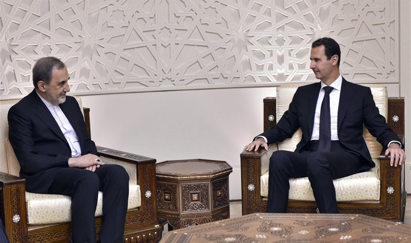 In this photo released by the Syrian official news agency SANA, Syrian President Bashar Assad, right, meets with Ali Akbar Velayati, an adviser to Iran's Supreme Leader Ayatollah Ali Khamenei, in Damascus, Syria, Tuesday, Nov 7, 2017. Syria's state-run news agency SANA said Assad and Velayati have vowed to defend their interests amid rising regional tensions. (SANA via AP)