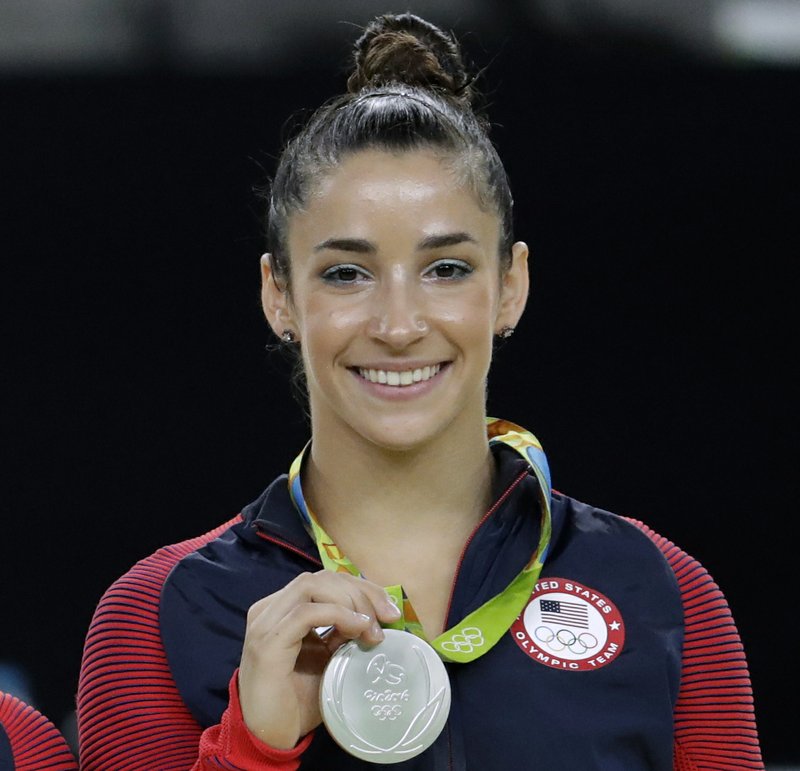 FILE - In this Aug. 16, 2016, file photo, United States' Aly Raisman shows off her silver medal after the artistic gymnastics women's apparatus final at the 2016 Summer Olympics in Rio de Janeiro, Brazil. Six-time Olympic medal winning gymnast Aly Raisman says she is among the young women abused by a former USA Gymnastics team doctor. Raisman tells &#x201c;60 Minutes&#x201d; she was 15 when she was first treated by Dr. Larry Nassar, who spent more than two decades working with athletes at USA Gymnastics but now is in jail in Michigan awaiting sentencing after pleading guilty to possession of child pornography. (AP Photo/Dmitri Lovetsky, FIle)