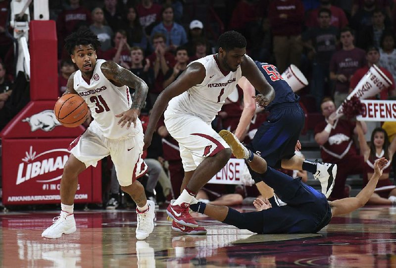 Arkansas Razorbacks guard Anton Beard (31) steals the ball from Samford’s Christen Cunningham as teammate Trey Thompson prepares to run the fast break Friday night at Walton Arena in Fayetteville. The Razorbacks opened the season with a 95-56 victory.