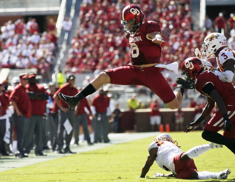 FILE - In this Oct. 7, 2017, file photo, Oklahoma quarterback Baker Mayfield (6) leaps over Iowa State defensive back De'Monte Ruth, bottom, in the second quarter of an NCAA college football game in Norman, Okla. The outright lead in in the Big 12 Conference is on the line when No. 5 Oklahoma hosts No. 8 TCU on Saturday (AP Photo/Sue Ogrocki, File)