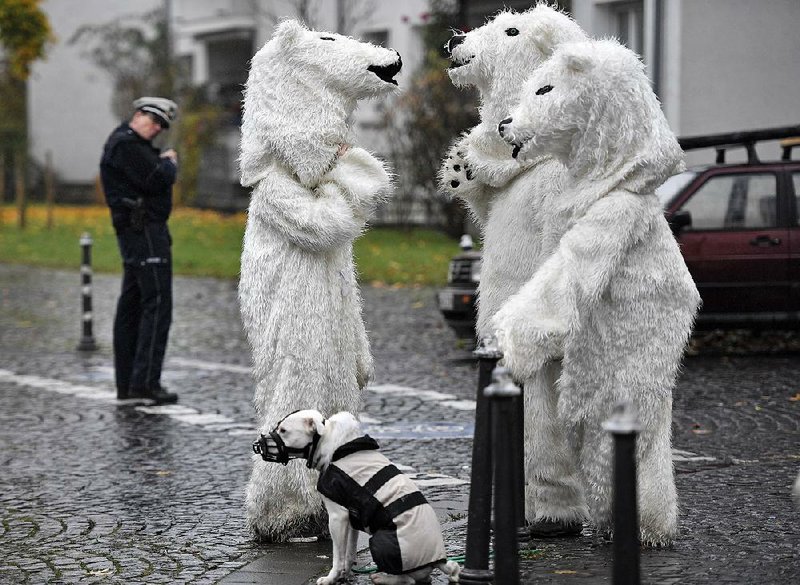 Police keep a close eye Saturday on protesters in polar bear costumes after a demonstration outside a United Nations climate conference in Bonn, Germany. An unofficial delegation from the United States is attending the conference.    
