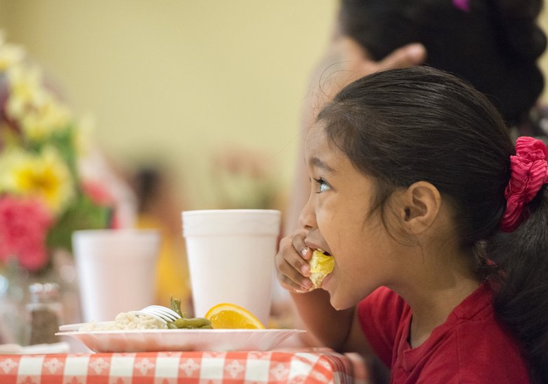 File Photo/CHARLIE KAIJO R.M. Lang, 4, of Springdale eats a fresh orange at the Samaritan Community Center in Springdale during a Northwest Arkansas Food Bank pilot program to move fresh produce to allied agencies more quickly.