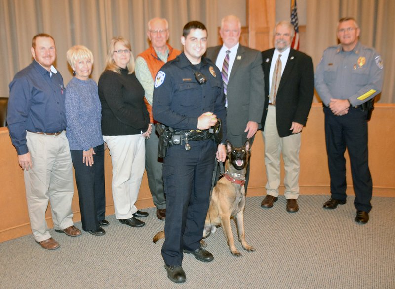Mike Capshaw/Siloam Sunday Members of Simmons Foods were presented a plaque from the Siloam Springs Police Department by Chief Jim Wilmeth (far right) for the company helping fund the purchase of a second K-9, named Frenkie, who also is picture with his handler, officer Travis Luper.