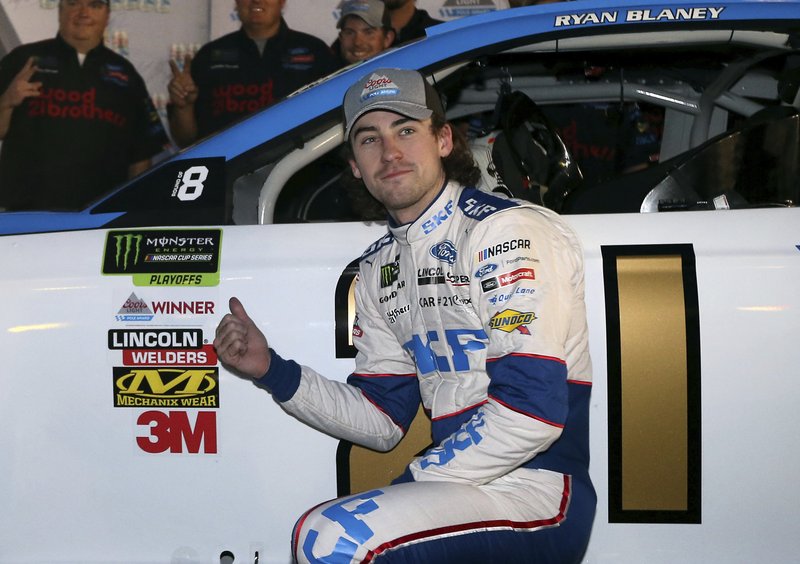 Ryan Blaney points to the pole award stuck on his car after winning the starting position for a NASCAR Cup Series auto race at Phoenix International Raceway, Friday, Nov. 10, 2017, in Avondale, Ariz. 