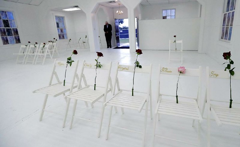 A memorial for the victims of the shooting at Sutherland Springs First Baptist Church, including 26 white chairs each painted with a cross on the back and holding a rose, is displayed in the church Sunday in Sutherland Springs, Texas.