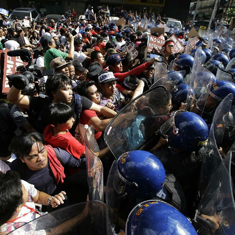 Protesters scuffle with police as they are dispersed while trying to get near the U.S. Embassy on Sunday in Manila, Philippines. The group was protesting against the visit of President Donald Trump.