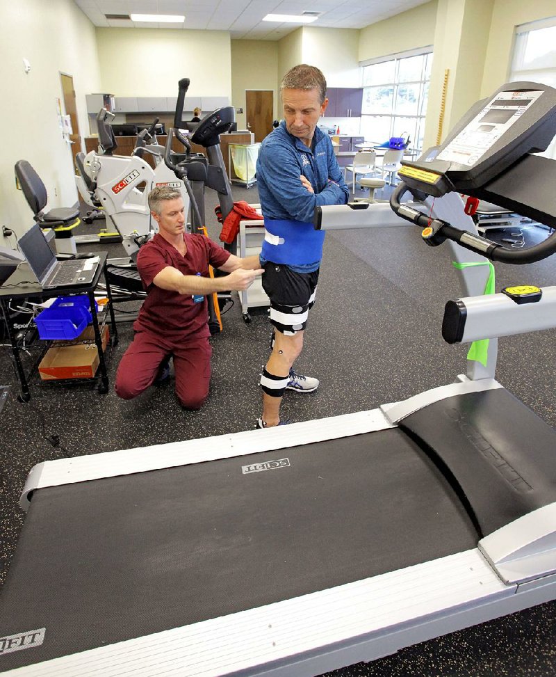 Gary Taylor cooperates while Chris Oholendt, rehab therapy manager, applies reflectors to key points on his lower body so he can undergo 3D Gait Analysis at the UAMS Orthopaedics Clinic.
