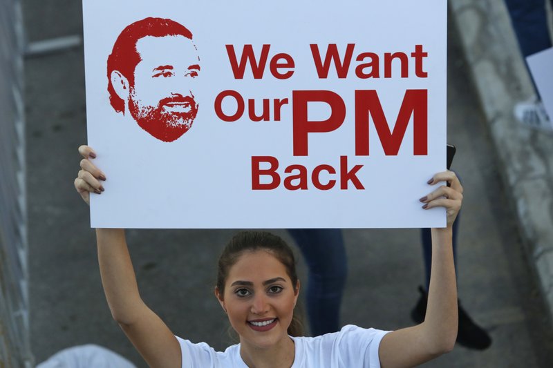 A Lebanese woman holds a placard supporting the outgoing Lebanese Prime Minister Saad Hariri to return from Saudi Arabia during the Beirut Marathon, in Beirut, Lebanon, Sunday, Nov. 12, 2017. Absent from the marathon this year is Hariri, a regular participant, who resigned from his post unexpectedly last week while in Saudi Arabia. The country's President Michel Aoun urged runners to call on the prime minister to return home. 