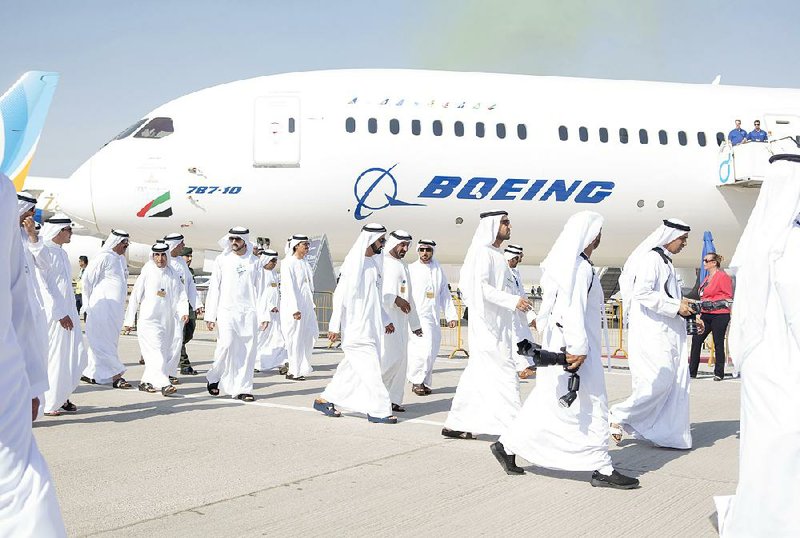 Officials pass an Emirates Airlines Boeing 787 during the Dubai Air Show on Monday.