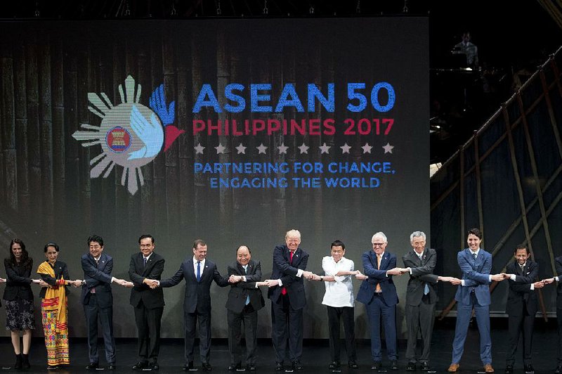 U.S. President Donald Trump (center) and other leaders do the “ASEAN-way handshake” on stage during the opening ceremony at the ASEAN Summit at the Cultural Center of the Philippines on Monday in Manila, Philippines.