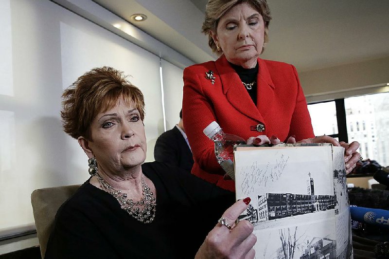 Beverly Young Nelson (left) and attorney Gloria Allred hold up Nelson’s high school yearbook, signed by Alabama Senate candidate Roy Moore, during a news conference Monday in New York. Nelson accused Moore of sexually assaulting her when she was 16 years old.