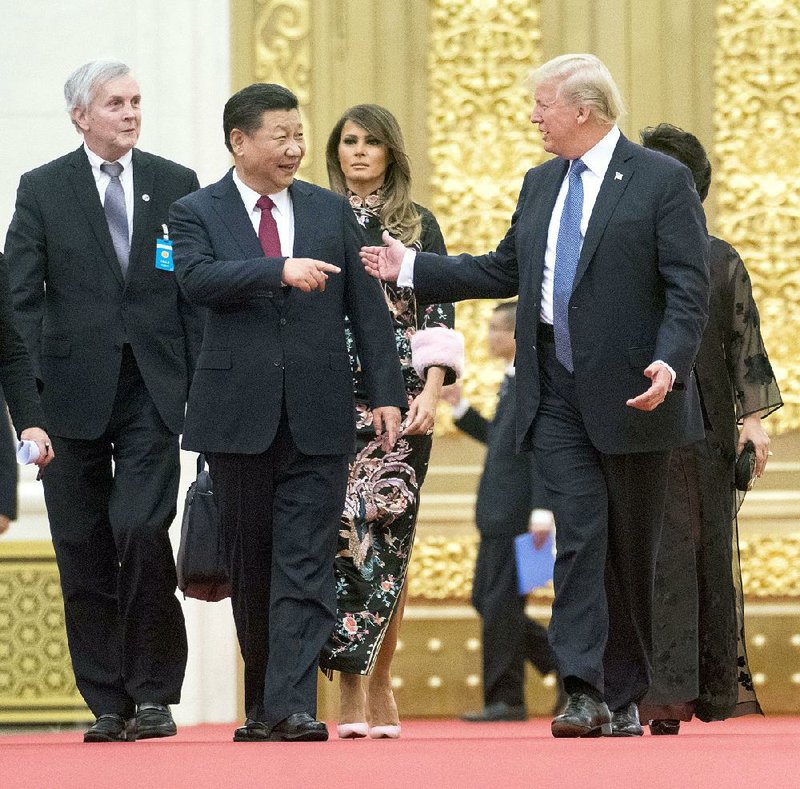 Chinese President Xi Jinping and President Donald Trump lead the way Thursday as they and their wives arrive for a state dinner in Beijing. 