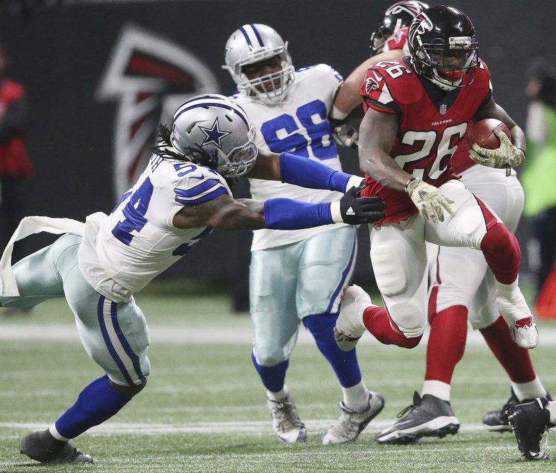 Atlanta Falcons running back Tevin Coleman (26) runs by Dallas Cowboys outside linebacker Jaylon Smith (54) during the second half of an NFL football game, Sunday, Nov. 12, 2017, in Atlanta. 