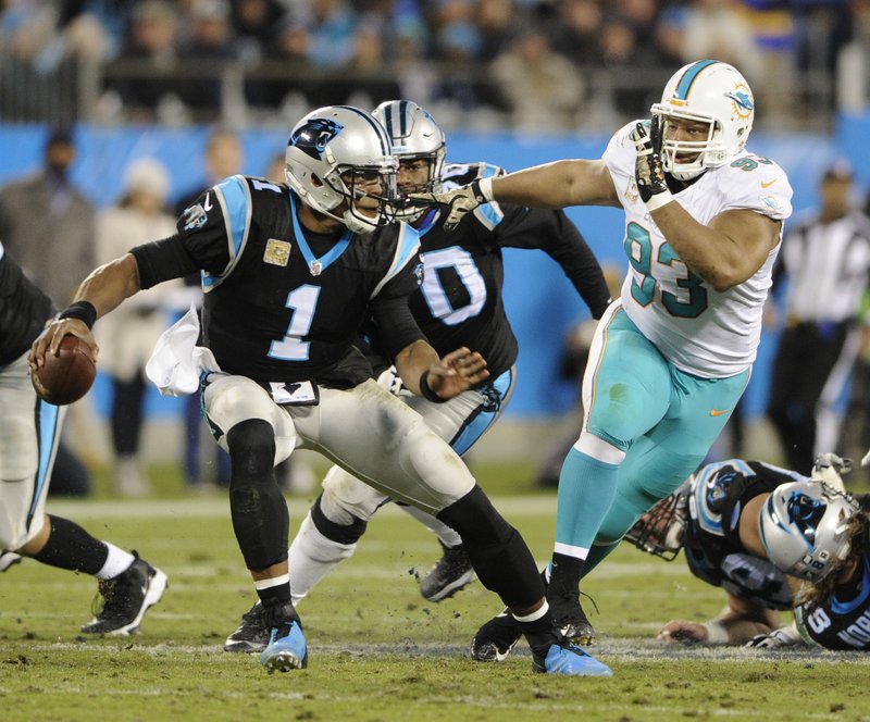 Carolina Panthers' Cam Newton (1) scrambles under pressure from Miami Dolphins' Ndamukong Suh (93) in the first half of an NFL football game in Charlotte, N.C., Monday, Nov. 13, 2017. 