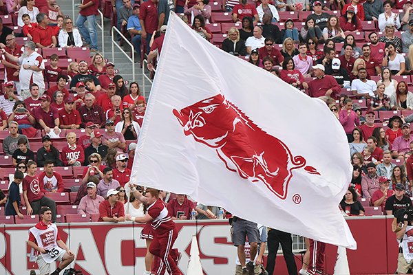 Arkansas cheerleader carries a flag around the stadium during a game against Coastal Carolina on Saturday, Nov. 4, 2017, in Fayetteville. 