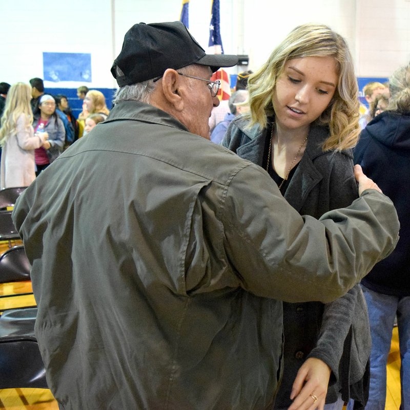 Photo by Mike Eckels Talor Thompson (right) gives her great-grandfather, Lester Austin, a hug at the end of the Decatur High School Veterans Day Celebration at Peterson Gym in Decatur Nov. 10. Austin, a lifelong resident of Decatur, served in the Army during the Korean War.