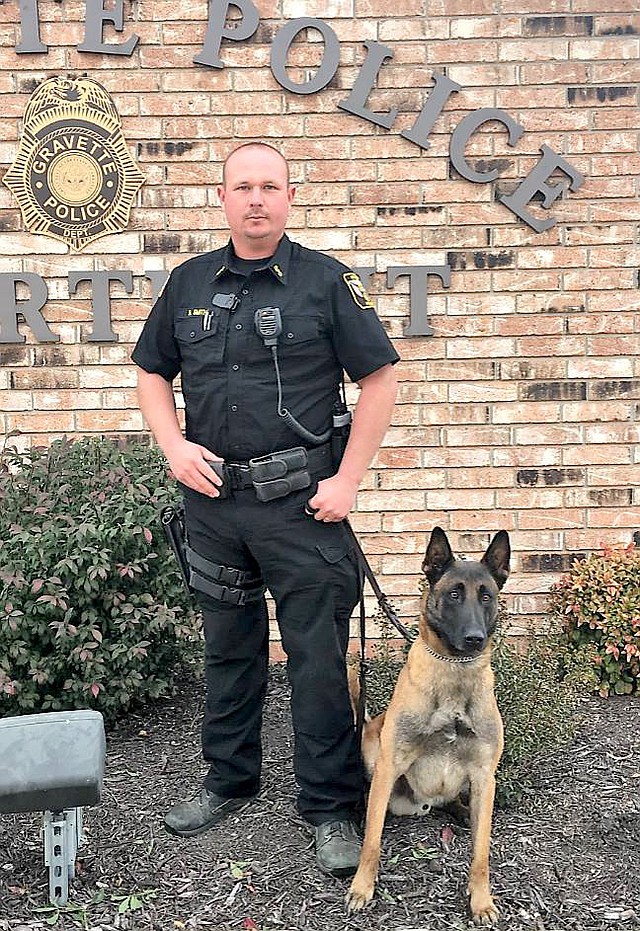 Submitted Photo Officer Bryan Smith has recently been promoted to corporal, according to a report by Gravette police chief Chuck Skaggs at the Nov. 9 committee of the whole meeting. Smith has been with the Gravette Police Department five years and has been a canine handler the last 18 months. He is pictured here with K-9 IKKS, the department's canine officer. Smith and K-9 IKKS were recently successful in locating a missing six-year-old with disabilities in the Highfill area. They tracked the boy into the woods and located him unharmed.