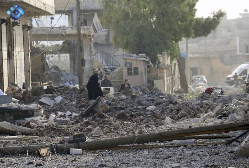 This image released by Thiqa News Agency shows people inspecting damage from airstrikes on Atareb, in the opposition-held countryside outside Aleppo Syria, Monday, Nov. 13, 2017. Syrian activists say at least 16 people have been killed in an airstrike on the market in a town in the north of the country. (Thiqa News via AP)