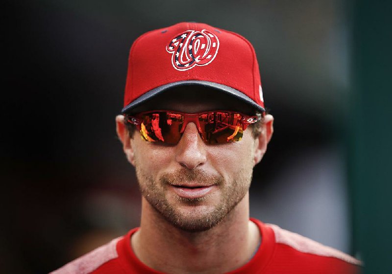 In this Aug. 30, 2017, file photo, Washington Nationals pitcher Max Scherzer stands in the dugout during the team's baseball game against the Miami Marlins at Nationals Park in Washington. 