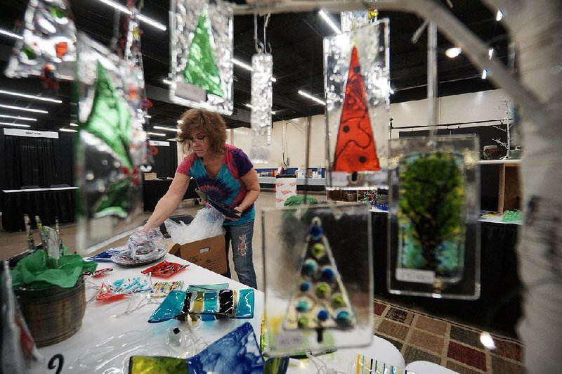 Katy Remmel of Little Rock sets out her fused glass pieces in preparation for last year’s Arkansas Arts Center Museum School Sale. This year’s sale of locally made artworks will be held this weekend. 