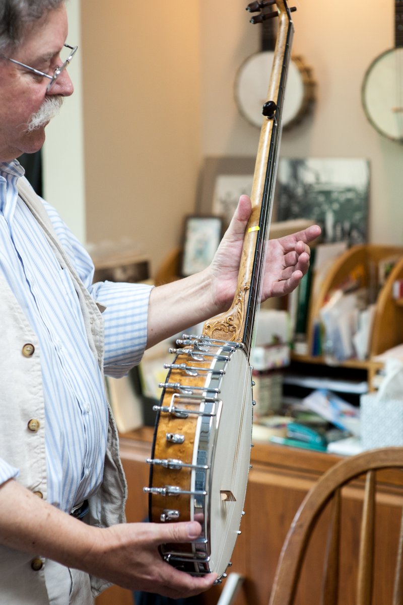 NWA Democrat-Gazette/LARA JO HIGHTOWER Clark Buehling, shown here in his music studio, has a large collection of banjos, his favorite stringed instrument. His passion is 19th-century banjo, mandolin and fiddle music.