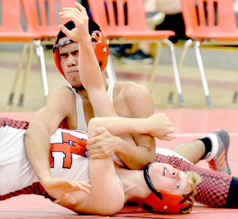 RICK PECKSPECIAL TO MCDONALD COUNTRY PRESS Jaw Di takes an elbow to the face on his way to pinning Justin Smith during the McDonald County High School wrestling team's annual Red/Black Dual held Nov. 10 at MCHS.