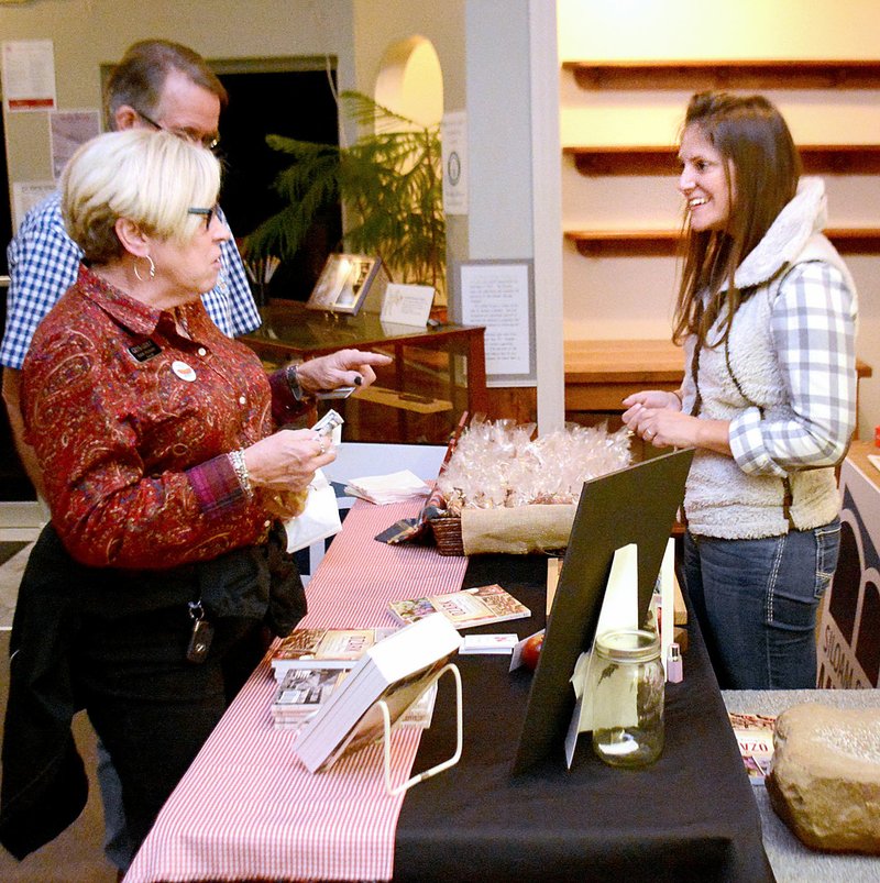 Janelle Jessen/Herald-Leader Chef Erin Rowe signed copies of her book An Ozark Culinary History: Northwest Arkansas Traditions from Corn Dodgers to Squirrel Meatloaf for Katie Rennard and Sid Townsend at the Siloam Springs Museum during the Tap into History event in October.