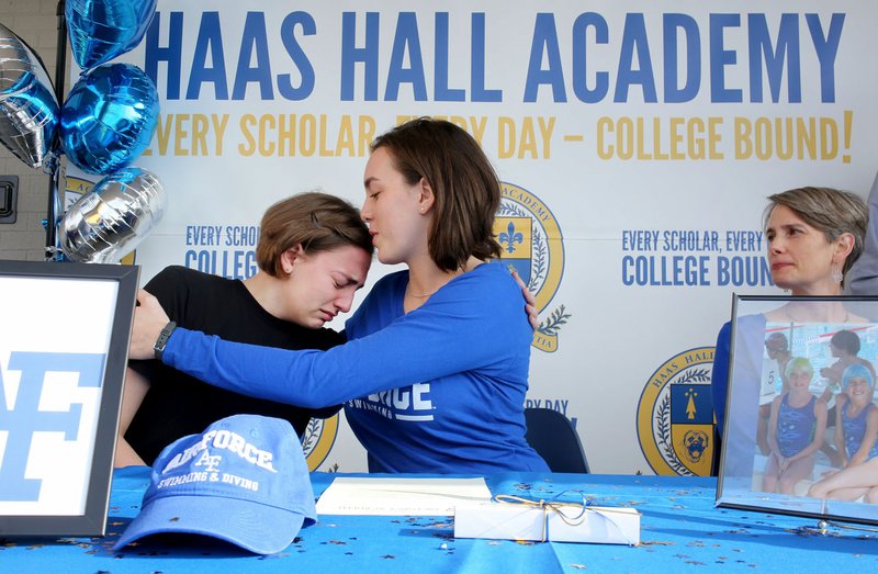 NWA Democrat-Gazette/DAVID GOTTSCHALK Corrine DeSpain (center) comforts her sister Lily, a freshman at Hass Hall Academy, Wednesday, November 11, 2017, as her mother Tiffany watches during her letter of intent signing ceremony at the Haas Hall Academy Starr Scholar Center in Fayetteville. DeSpain signed to swim for the U.S. Air Force Academy.