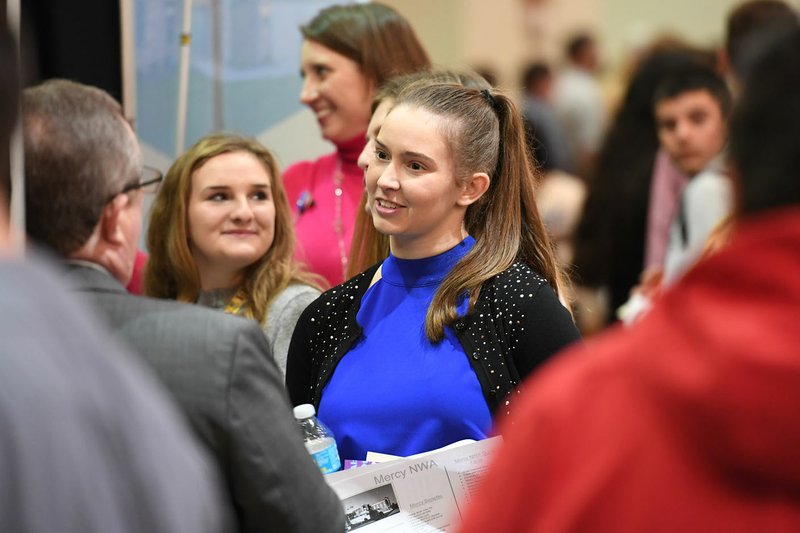 NWA Democrat-Gazette/J.T. WAMPLER Hannah Blackmon of Bentonville talks Tuesday with Les Abercrombie, vice president of human resources at Northwest Health Systems at the Springdale's Chamber of Commerce Workforce Summit. Students had the opportunity to speak with representatives from health, construction and other industries.