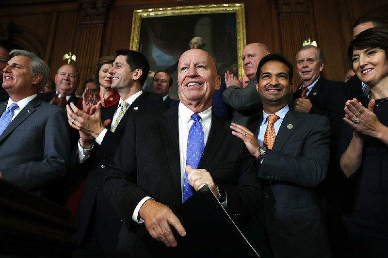 House Ways and Means Committee Chairman Kevin Brady (center) is congratulated Thursday by fellow GOP House members, including Speaker Paul Ryan (left), after passage of the House tax overhaul plan.