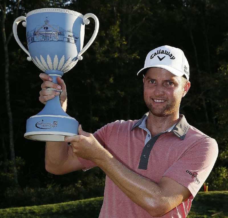Chris Kirk holds up the trophy after winning the Deutsche Bank Championship golf tournament in this 2014 file photo.