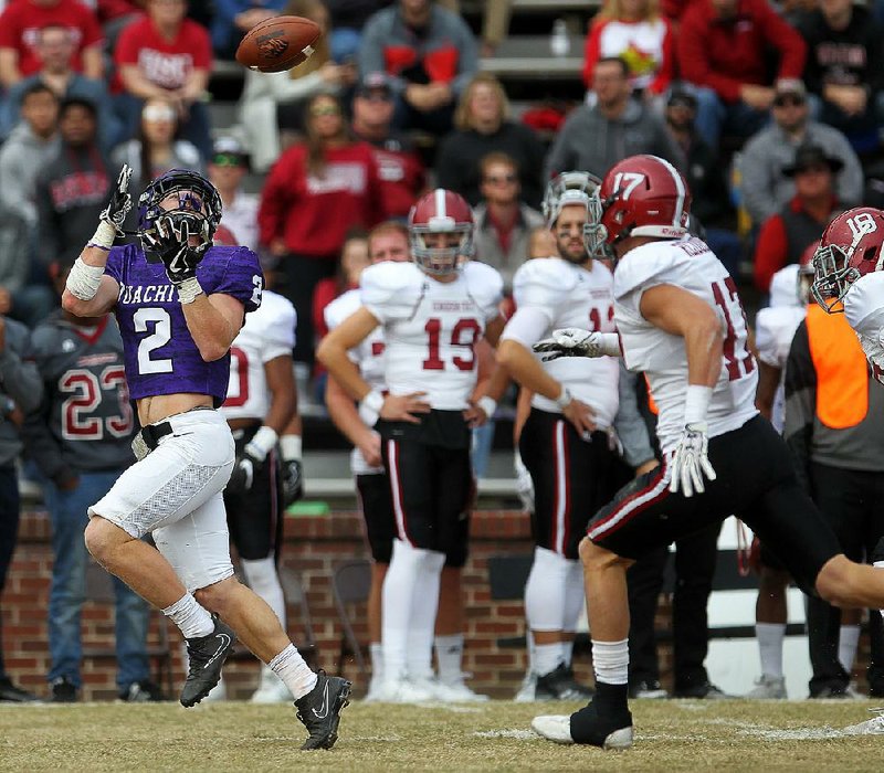 Ouachita Baptist wide receiver Drew Harris (2) pulls in a touchdown reception over Henderson State defensive backs Bowen Sweeney (17) and Malcom Scott (18) during the first quarter of OBU’s 49-42 victory Saturday at Cliff Harris Stadium in Arkadelphia. Harris leads the Tigers into Saturday’s opening round of the NCAA Division II playoffs against Ferris State in Big Rapids, Mich. 