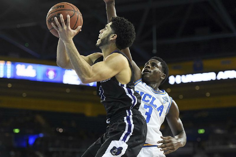 University of Central Arkansas guard Jordan Howard (left) shoots against UCLA’s Aaron Holiday on Wednesday night in Los Angeles. Howard scored 35 points to pace UCA in its 106-101 overtime loss. 