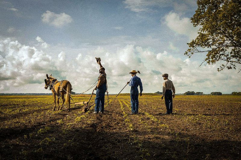Tenant farmer Hap Jackson (Rob Morgan) and his sons Marlon (Frankie Smith) and Weeks (Kelvin Harrison Jr.) work the soil in Mudbound.