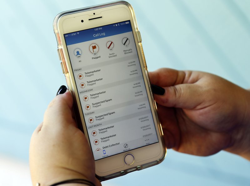 FILE - In this Tuesday, Aug. 1, 2017, file photo, Jen Vargas looks at a call log displayed via an AT&T app on her cellphone at her home in Orlando, Fla. The app helps locate and block fraudulent calls although some robocalls still get through. On Thursday, Nov. 16, 2017, the Federal Communications Commission adopted new rules giving phone companies greater authority to block automated messages known as robocalls from reaching customers. (AP Photo/John Raoux, File)